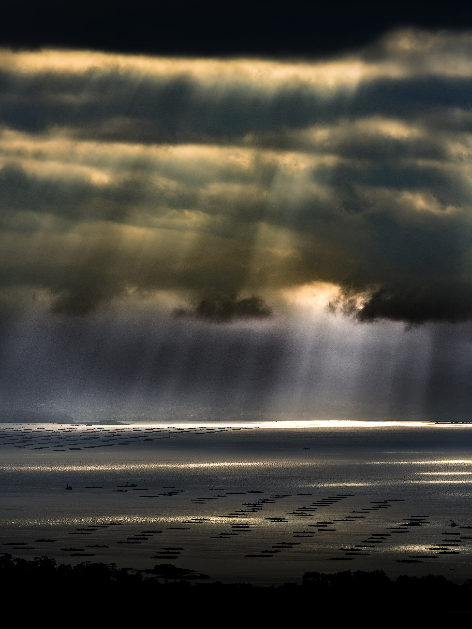 Sunbeams breaking through the clouds over the waters of the Ría de Arousa