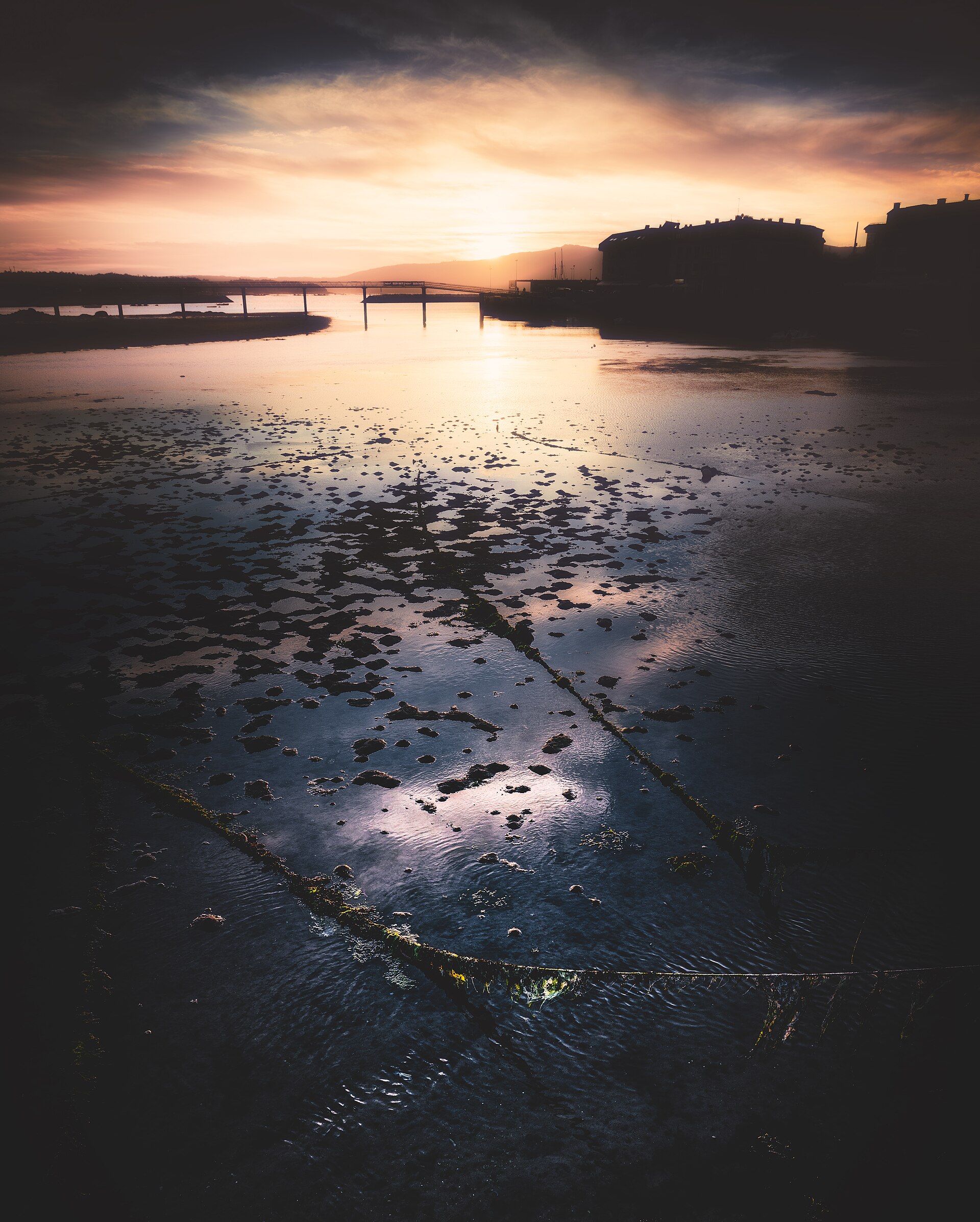 Coucher de soleil d'automne sur la Ría de Arousa à Vilanova, à marée basse avec le pont en arrière-plan