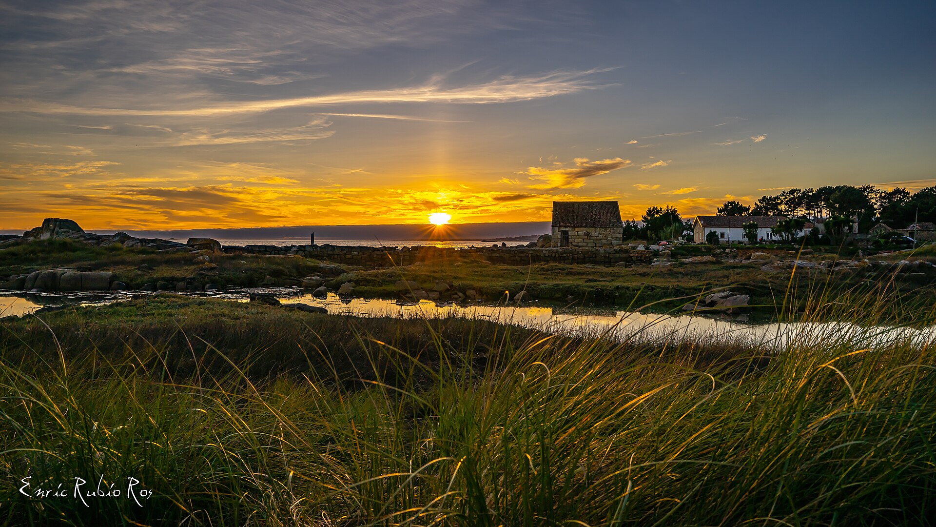 Vista de la Illa de Arousa al atardecer con el cielo anaranjado sobre la ría