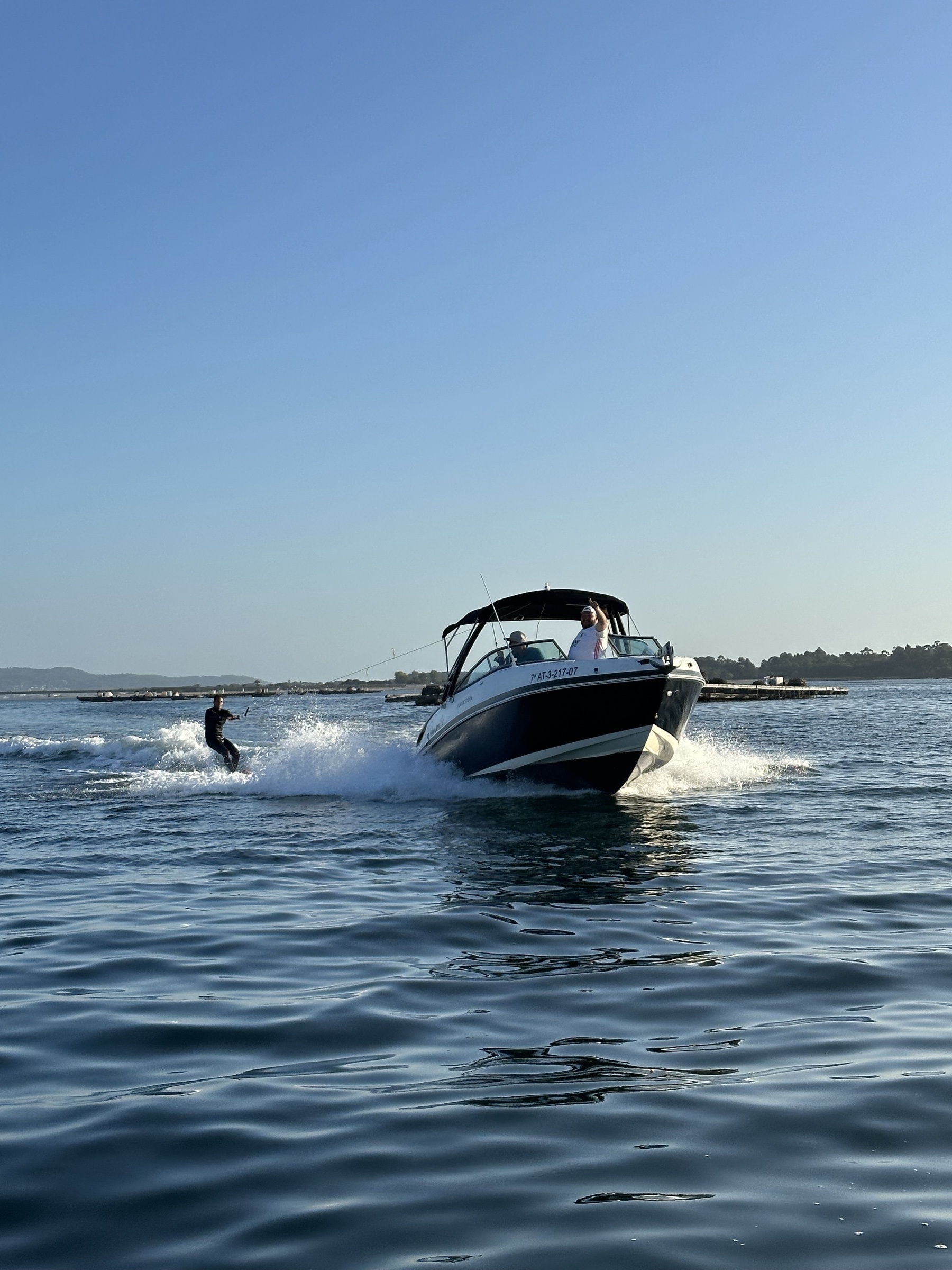 Barco Rinker tirando de un wakeboarder en aguas planas de la Ría de Arousa al amanecer